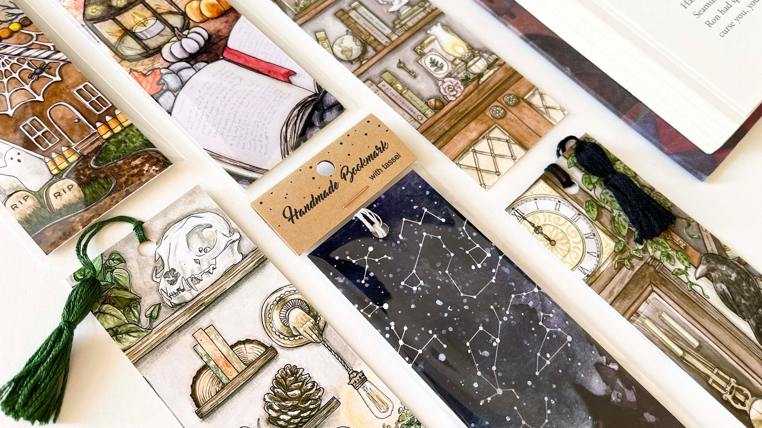 Three astrology-themed bookmarks with tasselssurrounded by crystals.