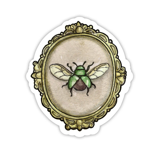 Bright green beetle with wings framed in an ornate gold frame.