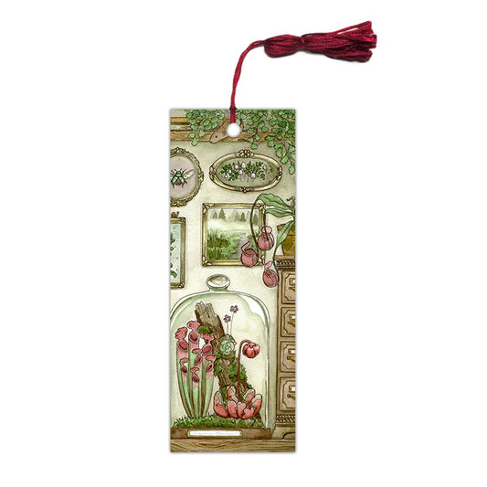Bookmark of a carnivorous plant terrarium next to antique frames with a red tassel.