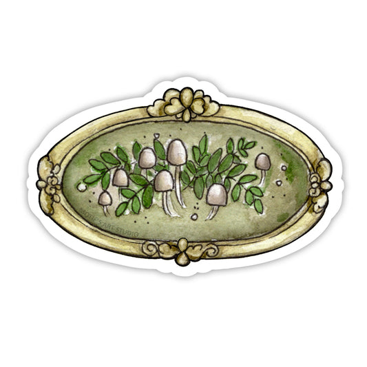 White mushrooms and ferns framed in a vintage gold frame.