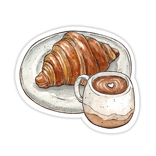 Sticker of a buttery flaky croissant  on a speckled plate with a cup of coffee in a ceramic neutral mug.