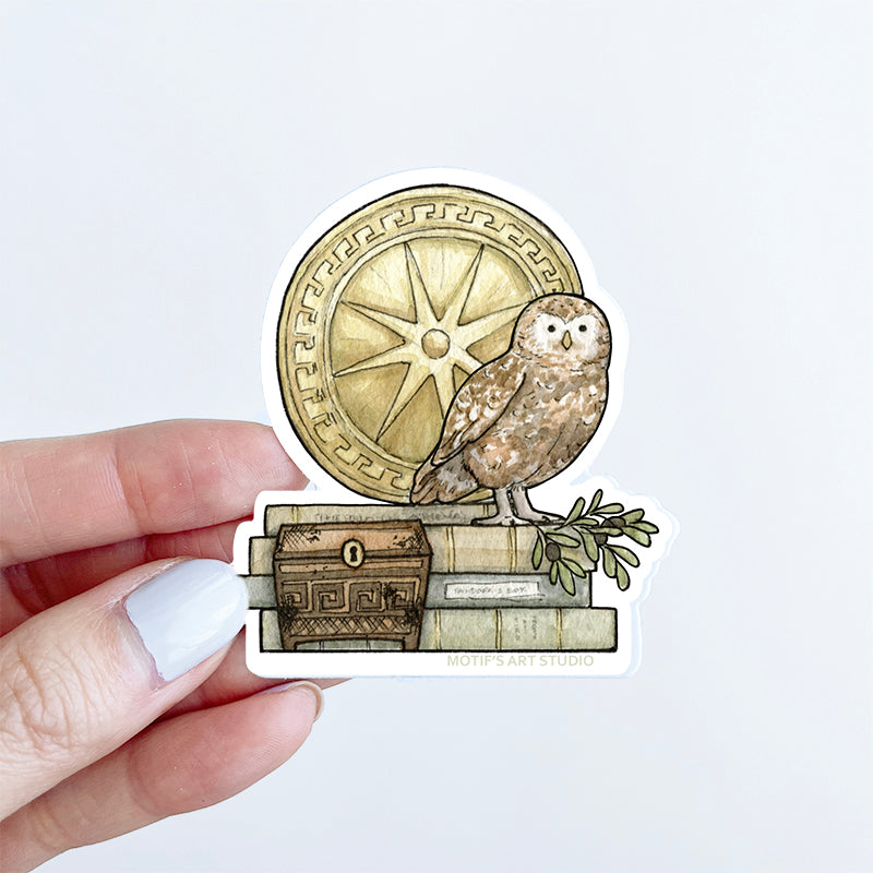 Sticker with an owl, Greek shield, and books held by a hand.