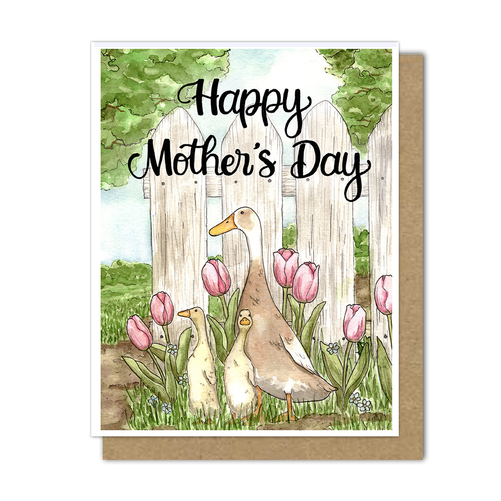 Greeting card with a watercolor painting of a mom duck with her two ducklings in grass in front of a white picket fence.