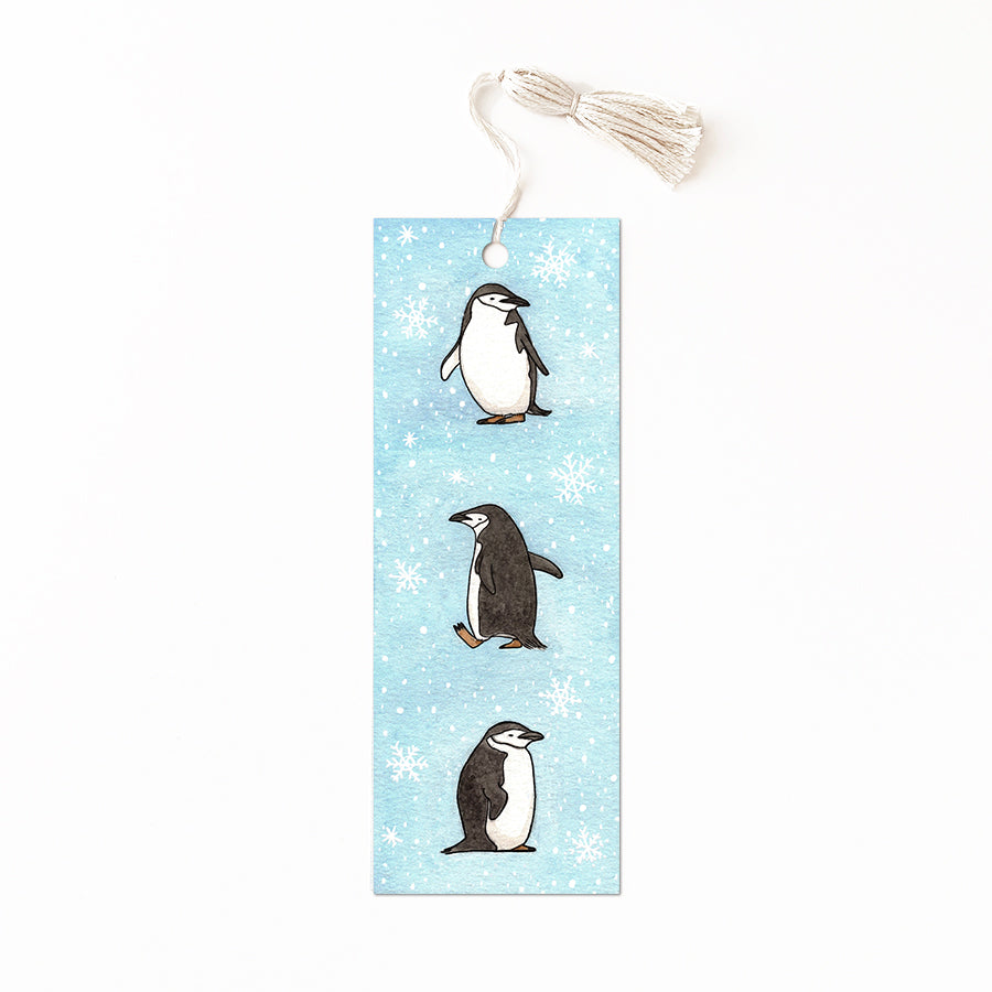 Blue bookmark with snowflakes and three cute penguins.