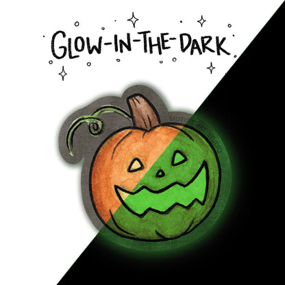 A Halloween-themed sticker of a jack-o'-lantern pumpkin with a carved face, shown on a split white and black background with the text 'GLOW-IN-THE-DARK' above it. The pumpkin face is split diagonally into orange and green, and the sticker has a dark gray outline with a faint glow effect.