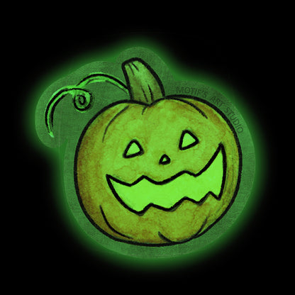 A die cut sticker featuring a hand-drawn glowing jack-o'-lantern with a carved face, set against a solid black background.