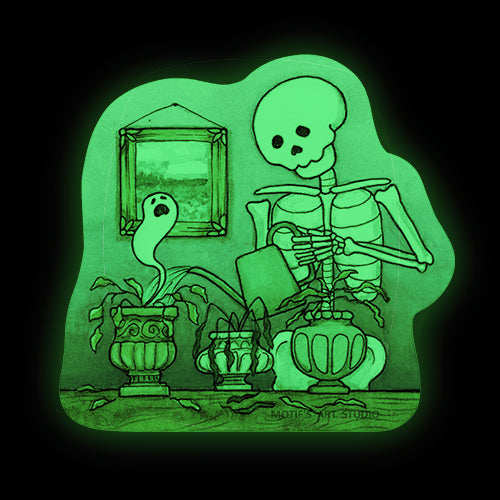 Glow in the dark sticker of a skeleton watering dead plants with a ghost in a room with a painting.